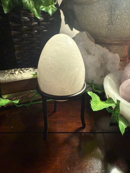 Decorative egg-shaped object on a stand with a textured background