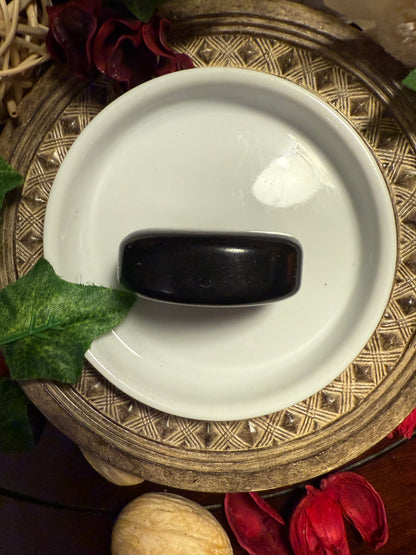Black object on a white plate with decorative background