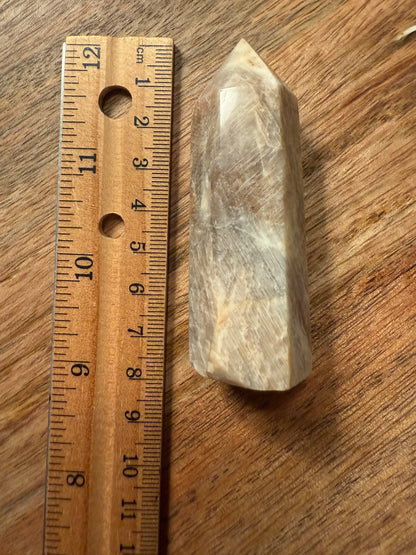 Crystal on a wooden surface next to a ruler for scale
