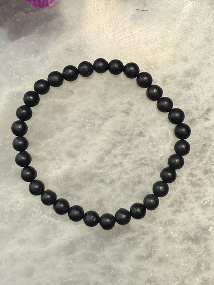 Black Natural Shungite Bead Bracelet on a gray surface