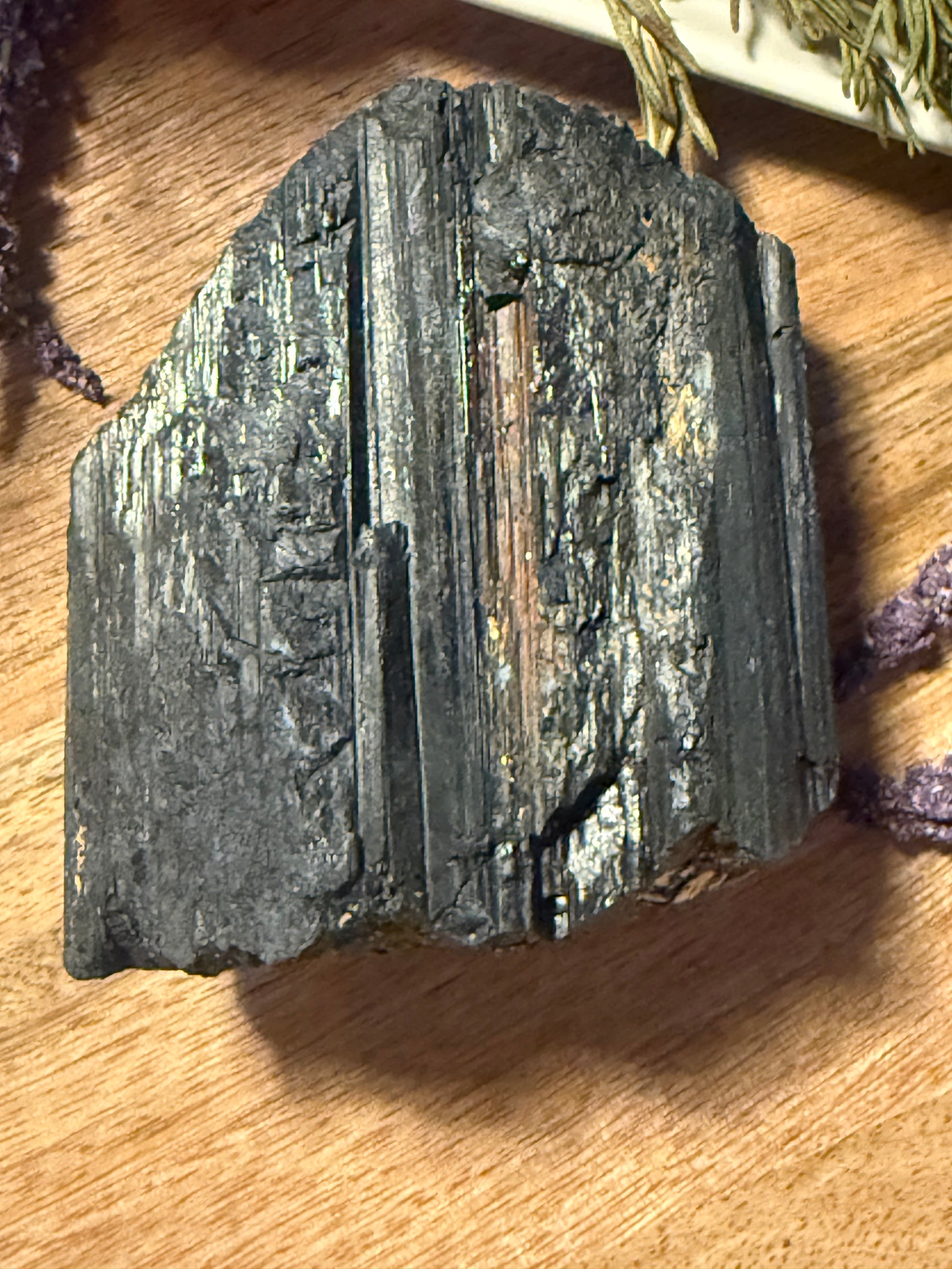 Raw Black Tourmaline on a wooden surface
