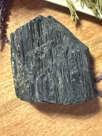 Raw Black Tourmaline on a wooden surface